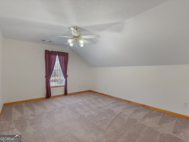 bonus room with light carpet, lofted ceiling, and ceiling fan