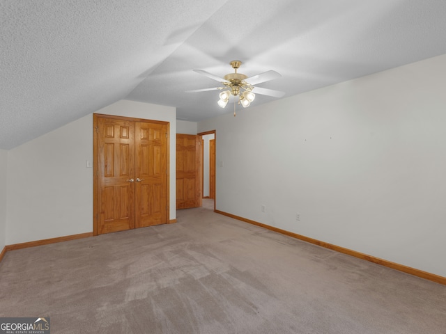 bonus room with light carpet, a textured ceiling, lofted ceiling, and ceiling fan