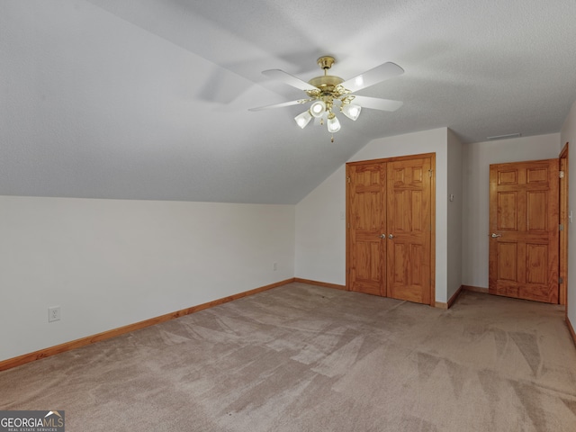 bonus room featuring light carpet, ceiling fan, lofted ceiling, and a textured ceiling