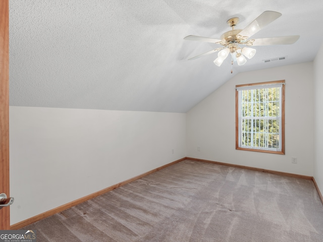 bonus room featuring light carpet, ceiling fan, vaulted ceiling, and a textured ceiling