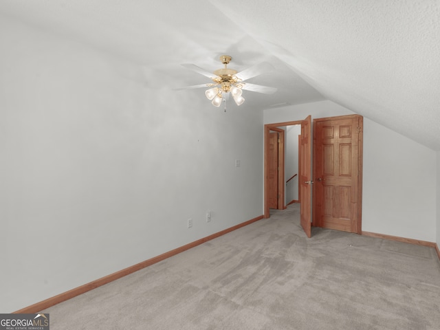 bonus room featuring light carpet, ceiling fan, vaulted ceiling, and a textured ceiling