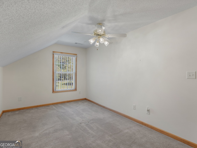 additional living space with lofted ceiling, ceiling fan, carpet floors, and a textured ceiling