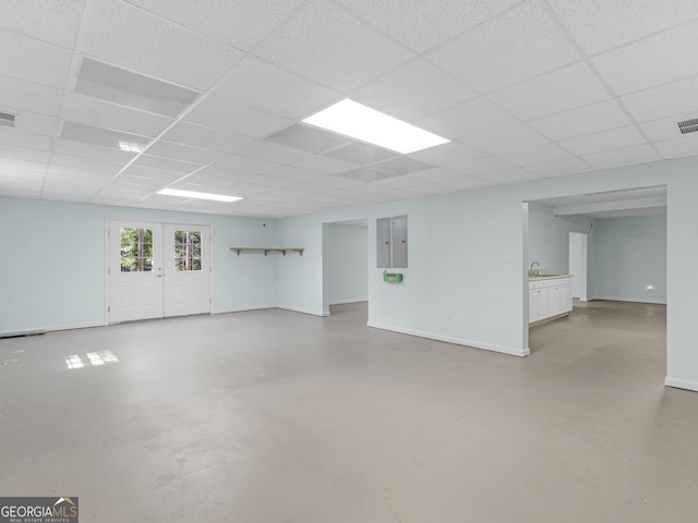 basement featuring a paneled ceiling and sink