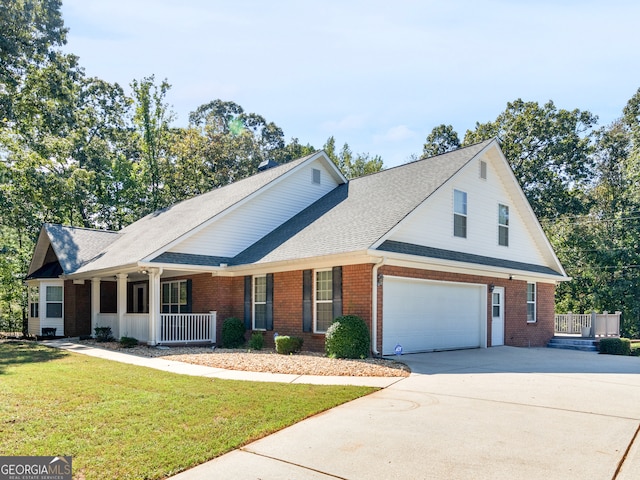 view of front of house featuring a porch, a front yard, and a garage