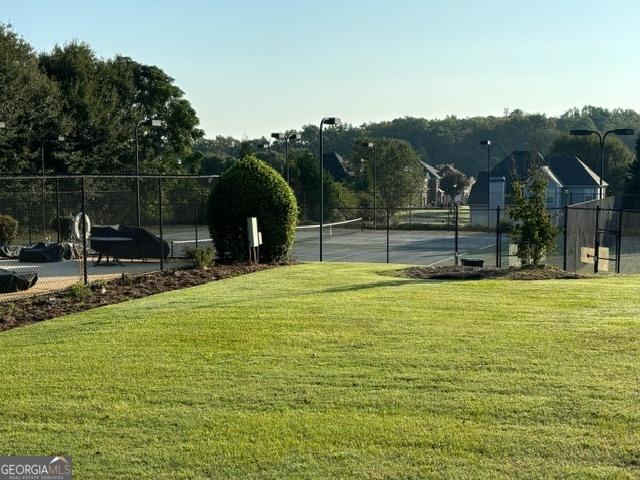 view of sport court featuring a yard