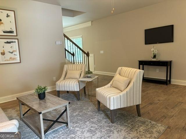 living area with ornamental molding and dark hardwood / wood-style flooring