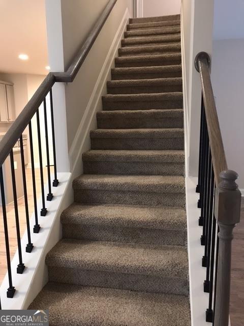 stairs featuring hardwood / wood-style floors