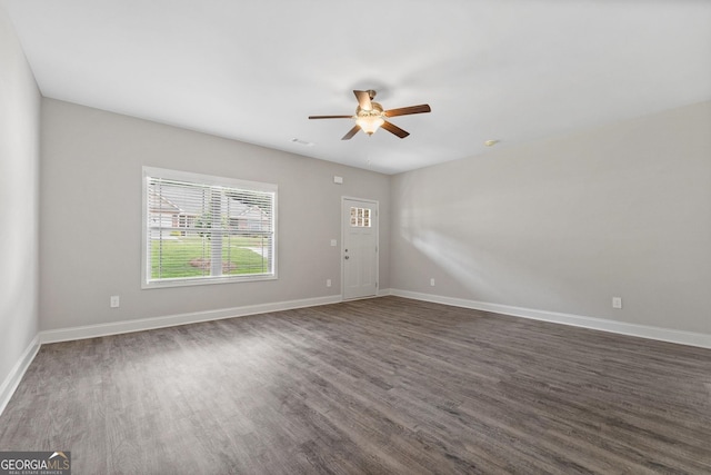 empty room featuring dark wood-type flooring and ceiling fan