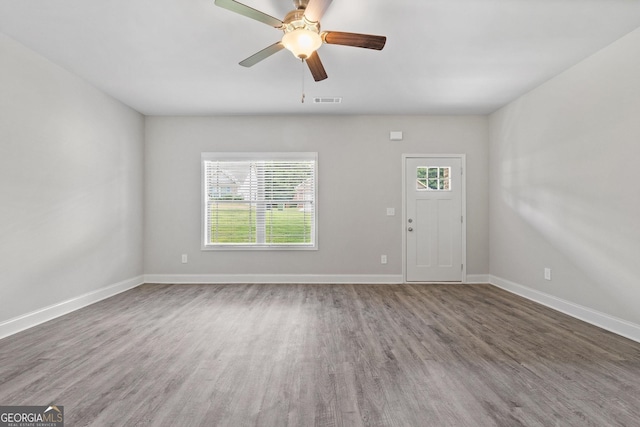 empty room with dark wood-type flooring and ceiling fan