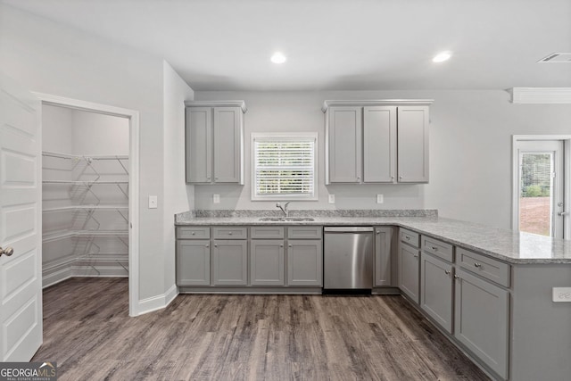 kitchen featuring sink, gray cabinetry, dark hardwood / wood-style floors, stainless steel dishwasher, and kitchen peninsula