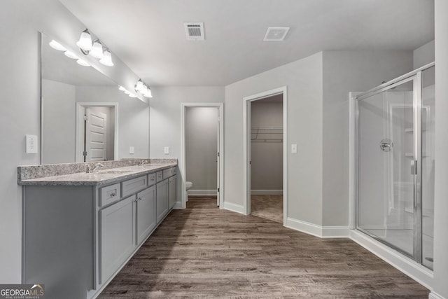 bathroom featuring an enclosed shower, vanity, hardwood / wood-style floors, and toilet