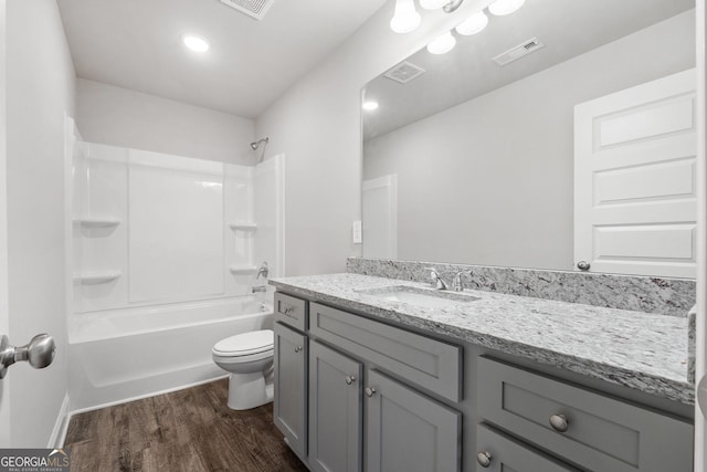 full bathroom with wood-type flooring, shower / washtub combination, vanity, and toilet