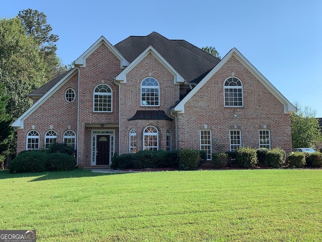 traditional home featuring brick siding and a front lawn