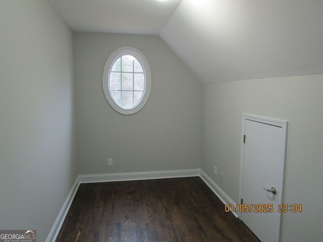 additional living space with dark hardwood / wood-style flooring and vaulted ceiling