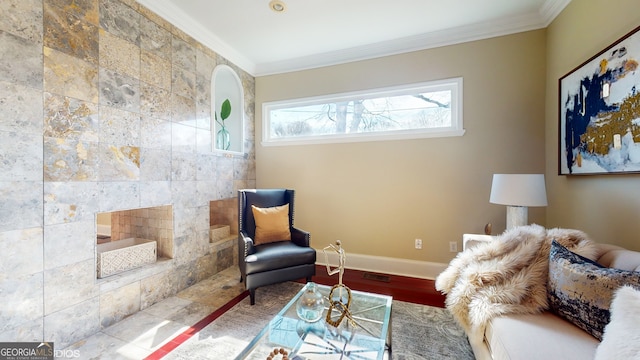 sitting room with hardwood / wood-style floors and crown molding