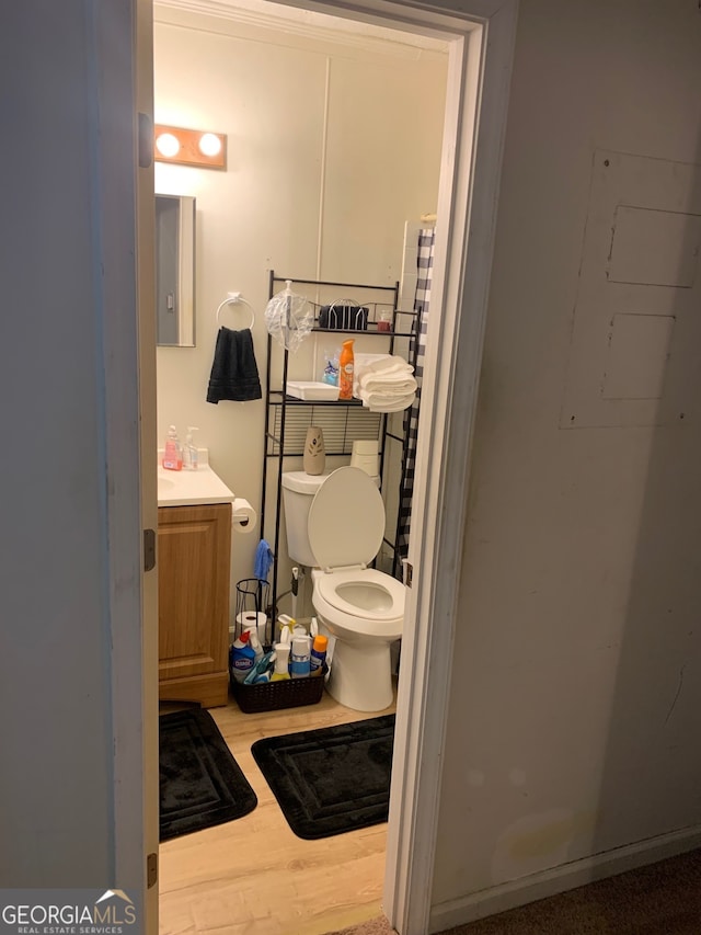 bathroom with hardwood / wood-style floors, vanity, and toilet