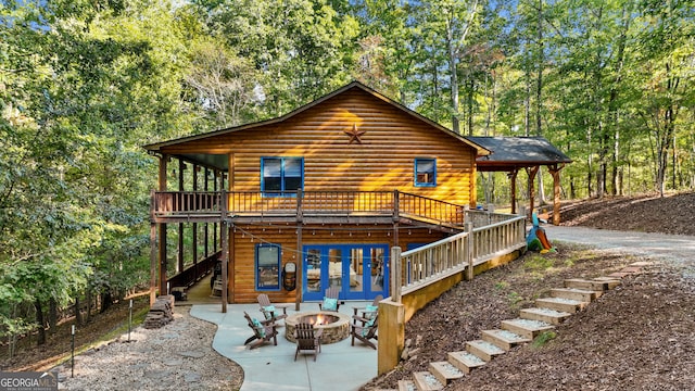 back of house featuring a wooden deck, a patio area, and a fire pit