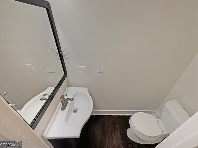 bathroom with hardwood / wood-style flooring and toilet