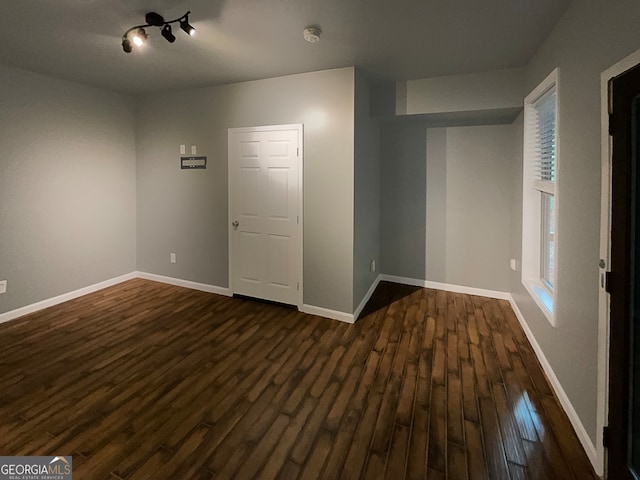 unfurnished room with dark wood-type flooring