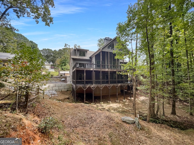 rear view of property featuring a sunroom