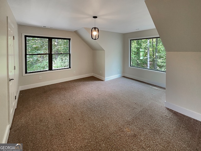 bonus room featuring carpet floors, a healthy amount of sunlight, and vaulted ceiling