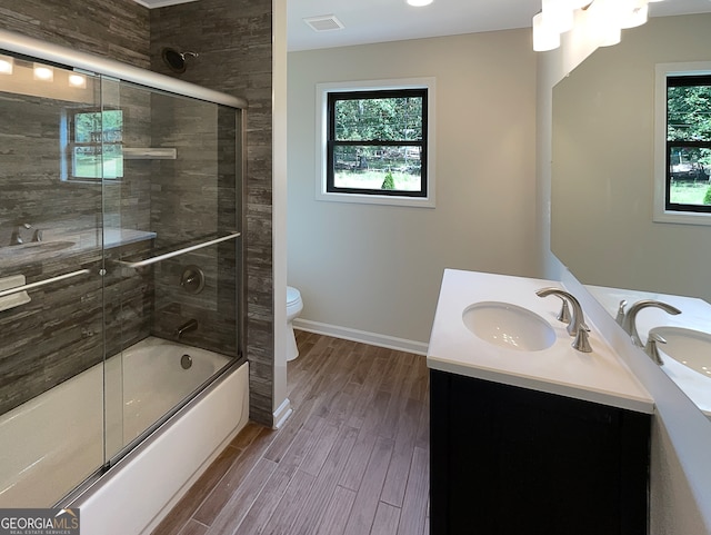 full bathroom featuring wood-type flooring, vanity, toilet, and plenty of natural light