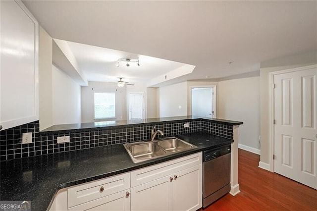 kitchen featuring dishwasher, a sink, dark countertops, tasteful backsplash, and white cabinets