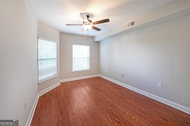 spare room featuring a ceiling fan, wood finished floors, and baseboards