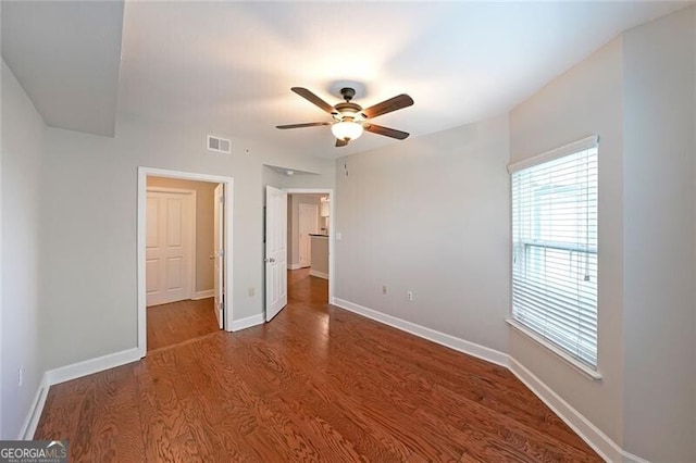 unfurnished bedroom with wood finished floors, baseboards, and a ceiling fan