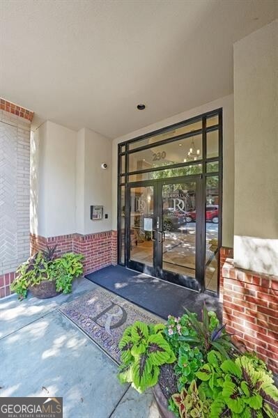 doorway to property with brick siding and stucco siding