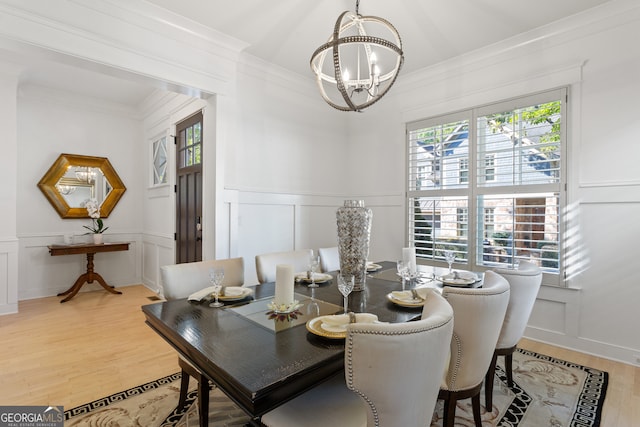 dining space with ornamental molding, a chandelier, and hardwood / wood-style floors