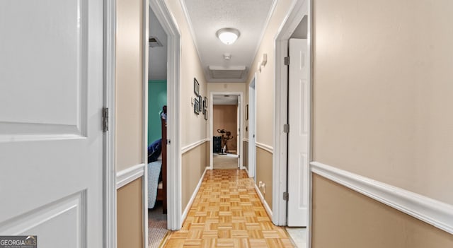 hallway with a textured ceiling and light parquet flooring