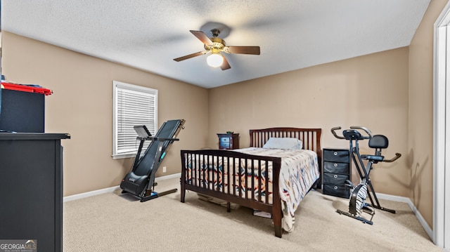 carpeted bedroom featuring ceiling fan and a textured ceiling