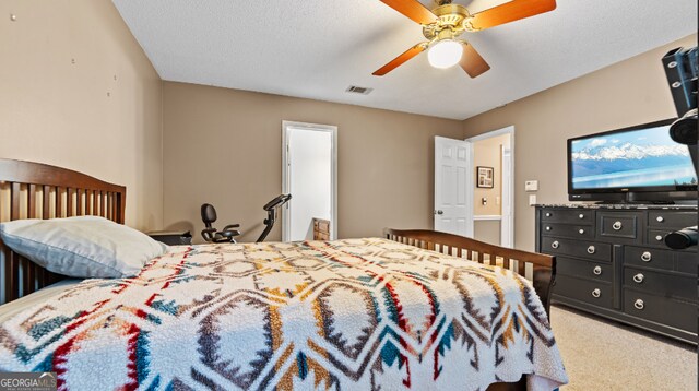 carpeted bedroom featuring ceiling fan and a textured ceiling