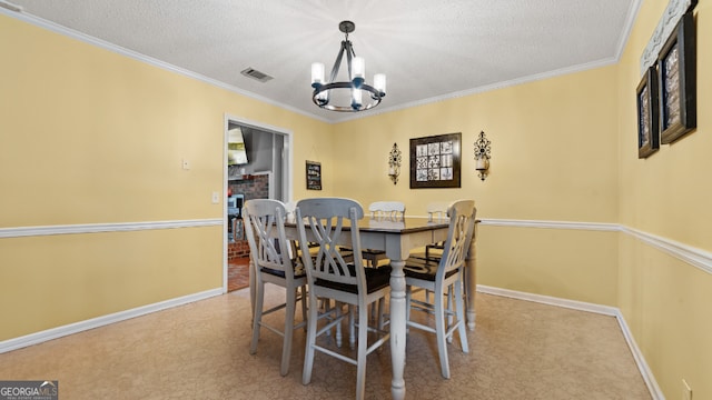 dining area featuring a textured ceiling, carpet flooring, ornamental molding, and a chandelier