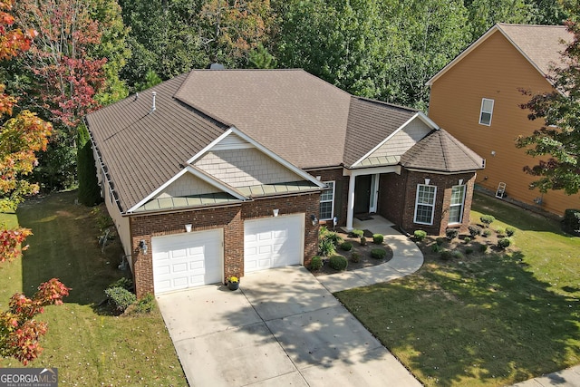 craftsman house featuring brick siding, a front yard, a standing seam roof, a garage, and driveway