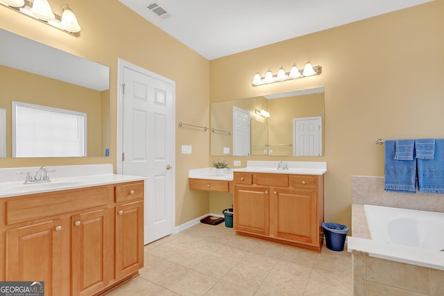 full bath featuring two vanities, visible vents, a sink, and a garden tub