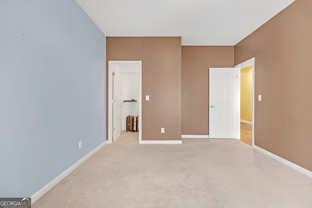 unfurnished bedroom with light carpet and baseboards