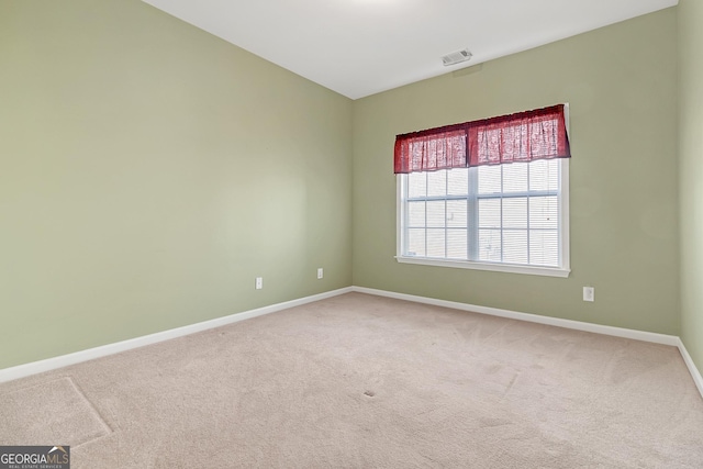 unfurnished room featuring baseboards, visible vents, and carpet flooring