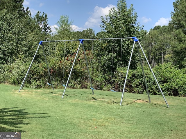 view of play area with a lawn and a wooded view