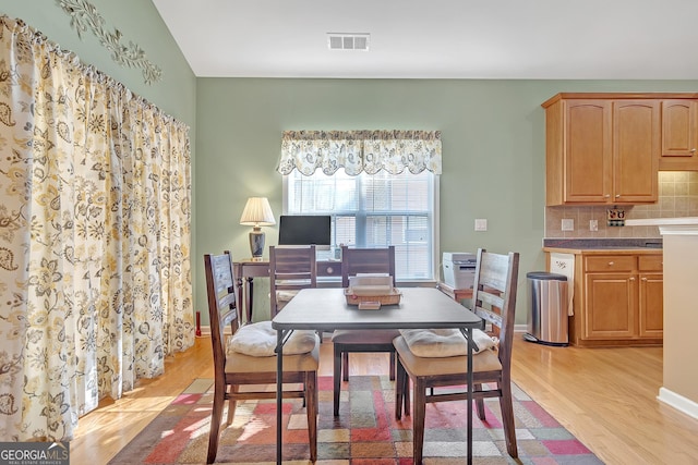 dining area featuring visible vents, light wood-style flooring, and baseboards