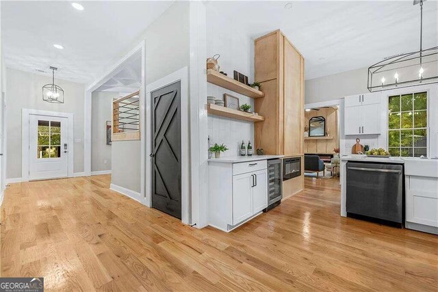 kitchen with dishwasher, light hardwood / wood-style floors, wine cooler, white cabinetry, and decorative light fixtures