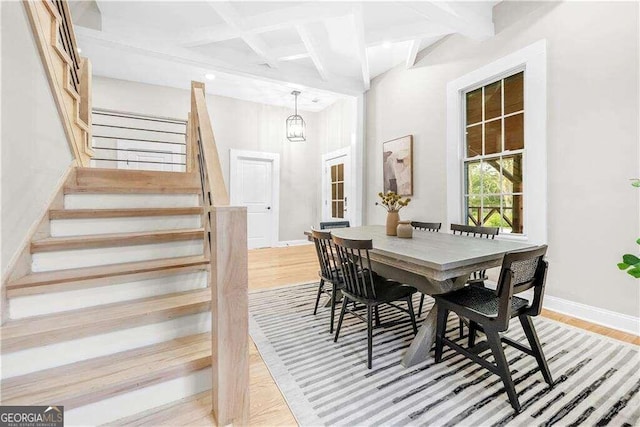 dining area featuring light hardwood / wood-style flooring, beam ceiling, and coffered ceiling