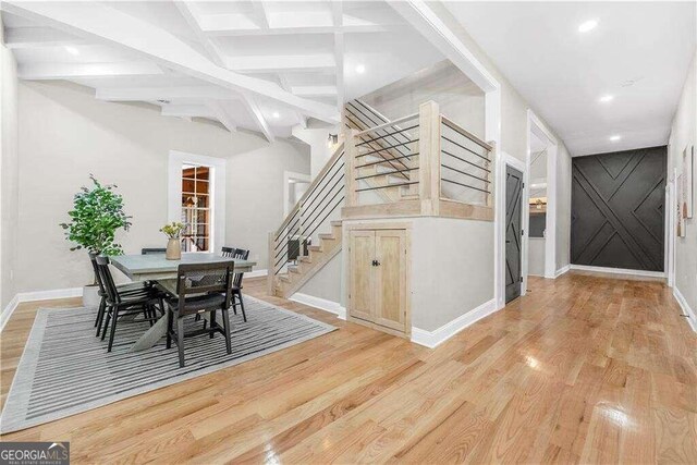 dining area featuring light hardwood / wood-style floors and beamed ceiling