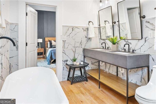 bathroom with tile walls, wood-type flooring, vanity, and toilet