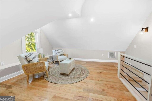 living area with vaulted ceiling and light hardwood / wood-style floors