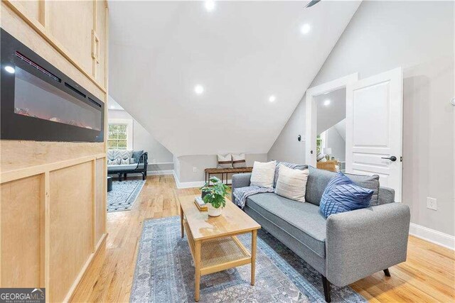 living room featuring light hardwood / wood-style floors and vaulted ceiling