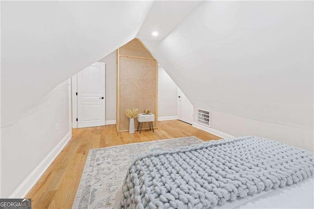 bedroom featuring hardwood / wood-style flooring and lofted ceiling