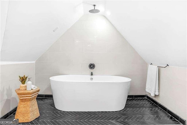 bathroom featuring plus walk in shower, lofted ceiling, and tile walls