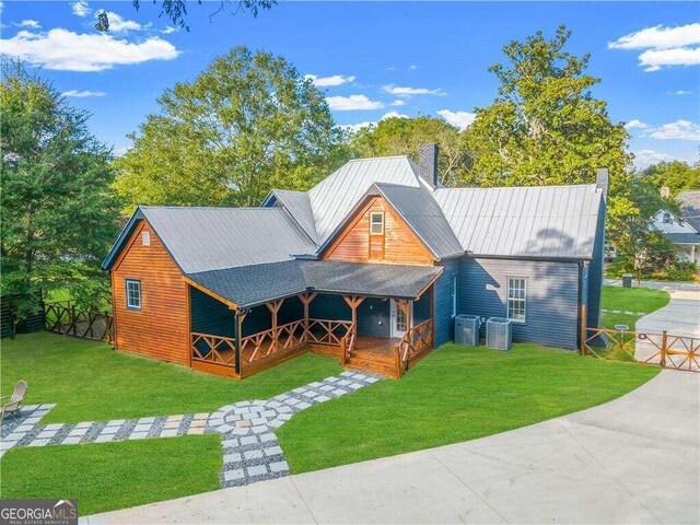 view of front of property featuring central AC and a front lawn